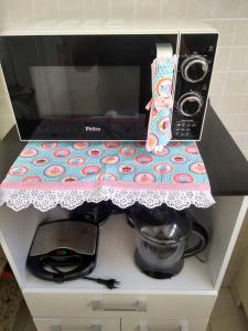 a kitchen counter with a counter top with a microwave at Apto Praia da Enseada 4 pessoas in Guarujá