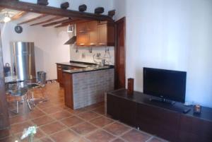 ein Wohnzimmer mit Küche mit Fernseher und Tisch in der Unterkunft Riojano y Coqueto in Logroño + 10 Fotos