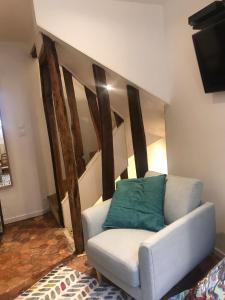 a living room with a white couch with a green pillow at Carré Saint-Gervais Rouen centre in Rouen