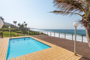 a swimming pool with the ocean in the background at Pebble Beach 13 in Ballito