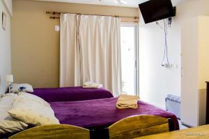 a bedroom with two beds with purple sheets and a window at Departamento Bicentenario y Parque in San Miguel de Tucumán