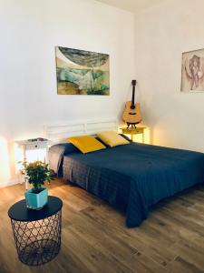 een slaapkamer met een groot bed en een gitaar bij Chalet del Centro in Napels