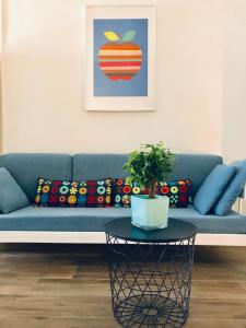 ein blaues Sofa mit Kissen und einen Tisch im Wohnzimmer in der Unterkunft Chalet del Centro in Neapel