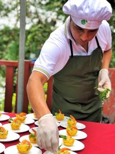 een chef-kok die eten bereidt op borden op een tafel bij Hotel Arazá - Lago Agrio in Nueva Loja