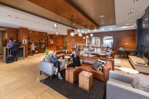 eine Gruppe von Menschen, die in einer Lobby auf Sofas sitzen in der Unterkunft The Heathman Hotel Kirkland in Kirkland