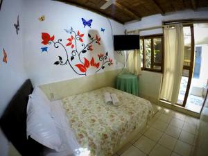 1 dormitorio con 1 cama con mariposas en la pared en La Posada, en Máncora