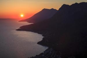 an image of the sun setting over the ocean at Apartments Josko in Gradac