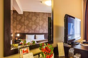 a hotel room with a bed and a television in a mirror at Hotel Villa Boyana - Free Parking in Sofia