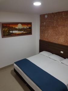 une chambre avec un lit et un tableau au mur dans l'établissement Zafara Hotel, à Santa Marta