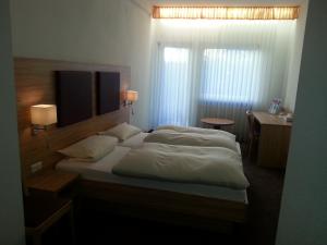 um quarto com uma cama, uma secretária e uma janela em Hotel Restaurant Rückert em Nistertal