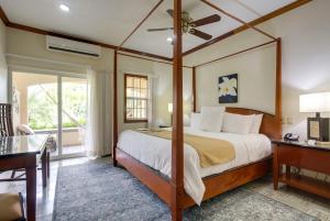 a bedroom with a large bed and a desk and a window at San Ignacio Resort Hotel in San Ignacio