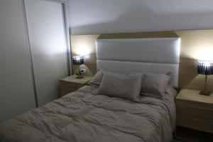 1 dormitorio con 1 cama con 2 mesitas de noche y 2 lámparas en Almar VI en 