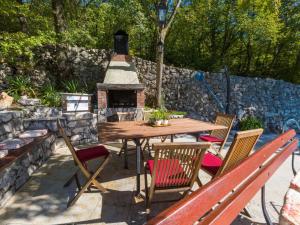 a patio with a table and chairs and a fireplace at House Casa Rustica in Grižane