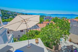 an umbrella on the roof of a building with trees at House Haus Marijo in Crikvenica