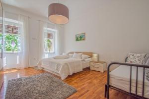 a bedroom with a bed and two windows at House Haus Marijo in Crikvenica