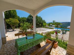 a patio with a table and a view of a garden at Apartment Agava in Bribir