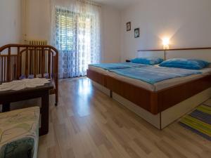 a bedroom with two beds and a table and a window at Apartments Nikica in Dramalj