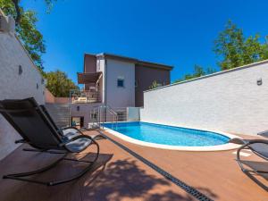 eine Terrasse mit einem Stuhl und einem Pool in der Unterkunft Apartments Alin in Dramalj