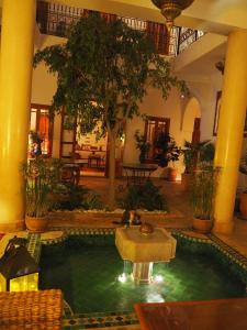 einen Pool in der Mitte eines Gebäudes mit einem Brunnen in der Unterkunft Riad Dar Kasal in Marrakesch