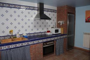 a kitchen with a sink and a microwave at Casa Rural Laura in Villafeliche