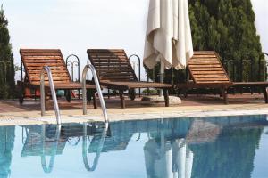 a group of chairs and umbrellas next to a swimming pool at Mythos in Elatochori