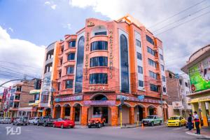 un edificio en una calle con coches aparcados delante en Gran Hotel Marcjohns, en Catamayo