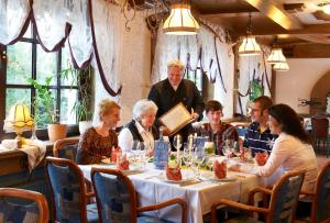 Hotel Restaurant Rückert في Nistertal: مجموعة من الناس يجلسون على طاولة في مطعم