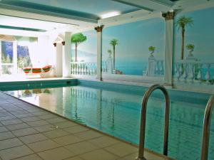 a swimming pool in a house with a painting on the wall at Hotel Restaurant Rückert in Nistertal