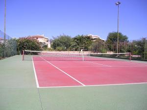 una pista de tenis con una red encima en Domenique en Budoni