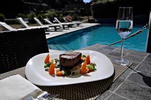 Ein Teller mit Essen auf einem Tisch neben einem Glas Wein in der Unterkunft Stocks Hotel in Sark