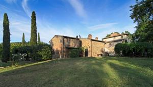 una antigua casa de piedra con un gran patio en Borgo San Benedetto en Montaione