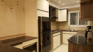 a kitchen with a black refrigerator and white cabinets at Sheraton Ocean 401 - No Pool Access in Cairo