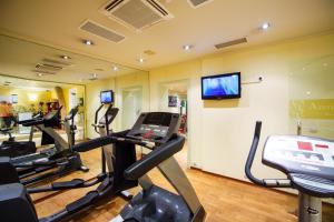 a gym with several tread machines and a flat screen tv at Arena Di Serdica Hotel in Sofia