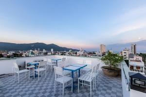 a patio with tables and chairs on a roof at Seashine Apartment in Da Nang