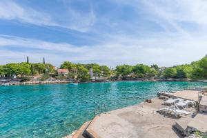 a large body of water with chairs and a beach at Apartment Vesna in Milna