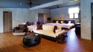 a large room with two beds and a couch and chairs at Magachabaru Okinawa in Nakijin