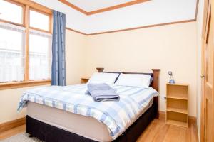 a bedroom with a bed with a blue curtain at Langdale Lodge in Kurow