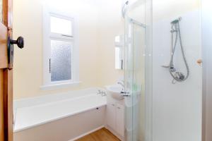 a white bathroom with a shower and a sink at Langdale Lodge in Kurow
