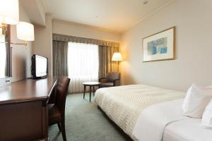a hotel room with a bed, desk, chair and lamp at Hotel Nikko Kansai Airport - 3 mins walk to the airport in Izumi-Sano