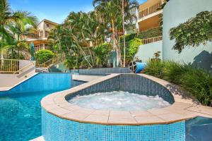a pool with a hot tub in the middle of a building at Lennox Beach Resort in Lennox Head