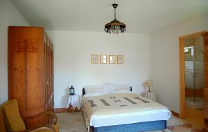 a bedroom with a bed and a chair and a chandelier at Nohab Apartman in Badacsonytördemic