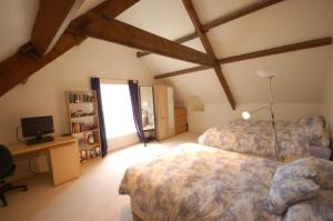 a bedroom with two beds and a desk and a television at Clemenstone House B&B in Cowbridge