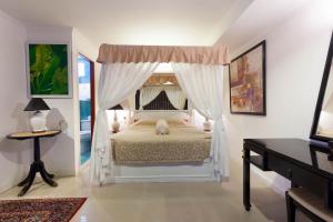 1 dormitorio con 1 cama blanca con dosel en Orchid Hotel and Spa Kalim Bay, en Patong Beach