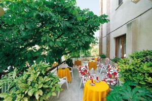 a group of tables and chairs with yellow and red table cloth at Hotel Risorgimento in Chianciano Terme