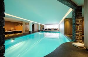 a large swimming pool in a hotel room at first mountain Hotel Montafon in Gaschurn +23 photos