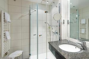 a bathroom with a sink and a glass shower at Hotel Domschenke in Billerbeck +36 photos