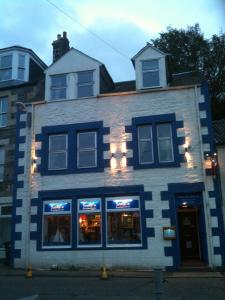 un edificio azul y blanco con luces en las ventanas en Struan House B&B, en Tarbert