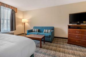 a hotel room with a bed and a couch and a tv at MainStay Suites Grantville in Grantville