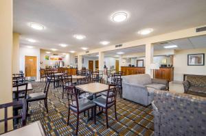a restaurant with tables and chairs and a couch at Quality Inn Fredericksburg-Central Park Area in Fredericksburg