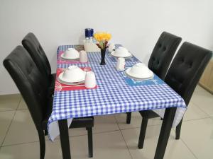 uma mesa com uma toalha de mesa azul e branca em Melaka Carol Leisure Stay em Malaca